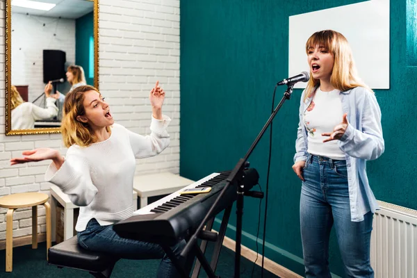 Donna cantante provare la sua canzone su una lezione con un insegnante — Foto Stock