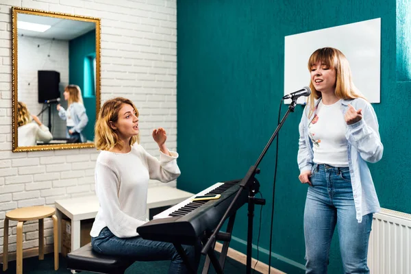 Woman vocalist singing in microphone on a vocal lesson — Stock Photo, Image