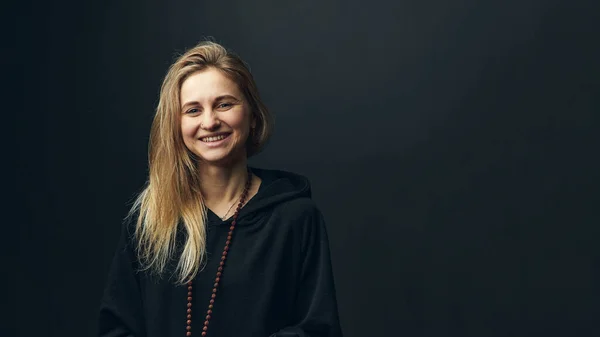 Sorrindo yogi mulher com rosário no pescoço em fundo preto. — Fotografia de Stock