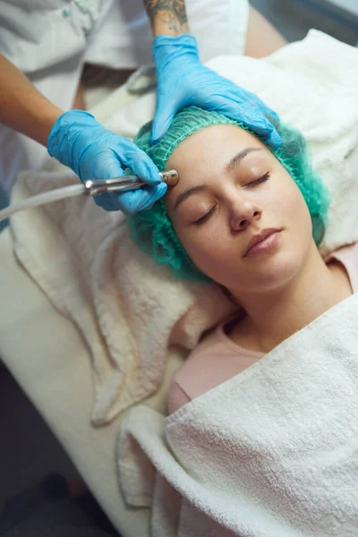Elmas mikro dermabrüksiyon. Güzellik uzmanı bir kadının yüzünde tedavi uyguluyor.. — Stok fotoğraf