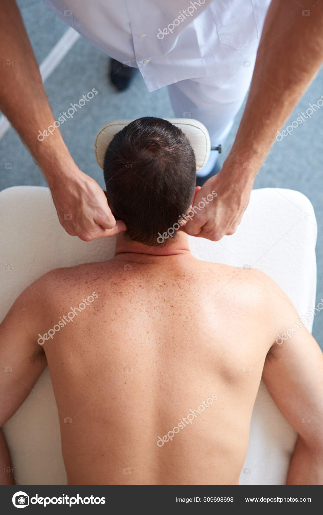 A man therapist massages the shoulder of a young girl. Massage therapy the  medical center. Stock Photo by Artranq