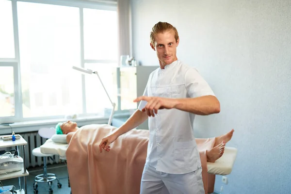 Confident smiling masseur pointing finger — Stock Photo, Image