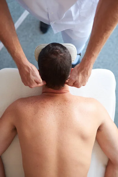 Massagist masseuring kopf von seine client auf ein tisch — Stockfoto