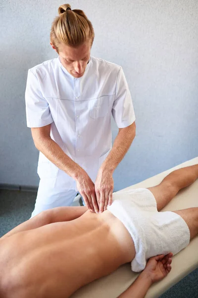 Professionelle Rückenmassage für Patienten im Liegen auf Massagetisch — Stockfoto
