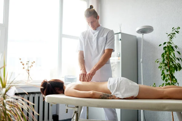 Frau erhält eine entspannende Rückenmassage an der Rezeption eines Masseurs. Massage und Körperpflege. — Stockfoto
