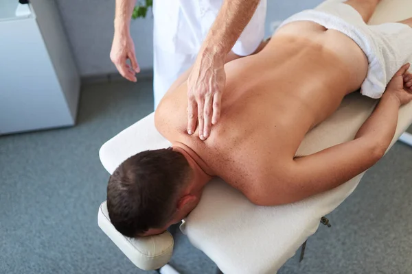 Primer plano del hombre mostrando técnicas de masaje en su paciente con las manos — Foto de Stock