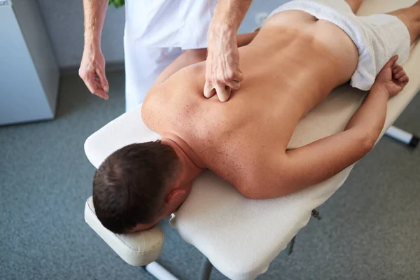 Primer plano del hombre mostrando técnicas de masaje en su paciente — Foto de Stock