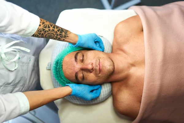Gülümseyen adam yüz masajı yaptırıyor — Stok fotoğraf