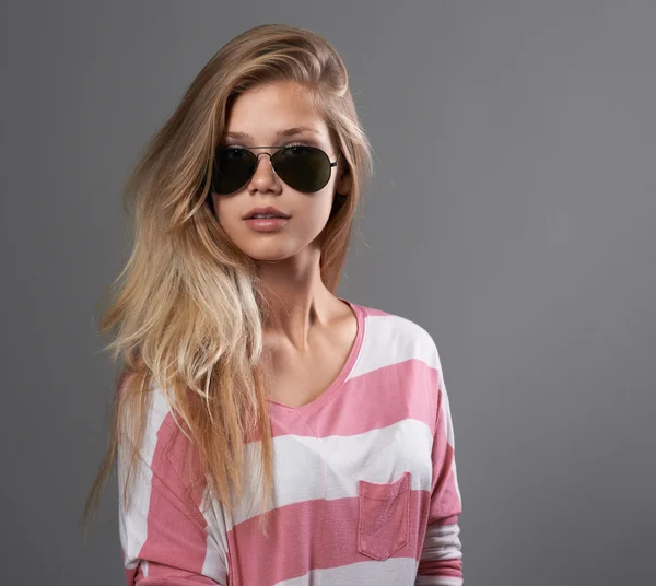 Girl in sunglasses on gray background — Stock Photo, Image