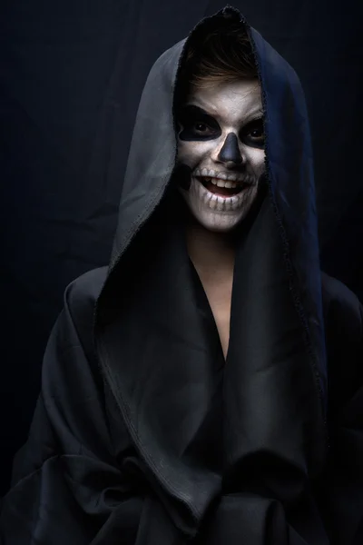 Tiener met make-up van schedel in zwarte mantel lacht — Stockfoto
