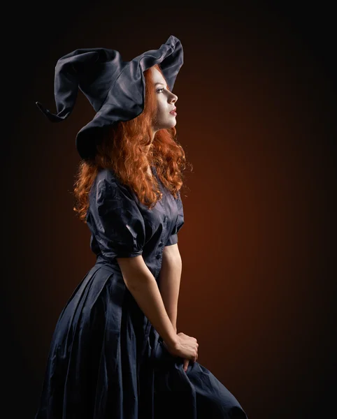 Beautiful red-haired girl in the witch costume — Stock Photo, Image