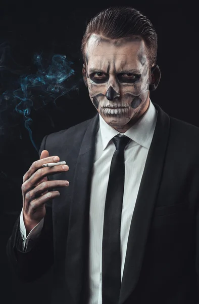 Retrato hombre de negocios fumar con maquillaje esqueleto — Foto de Stock