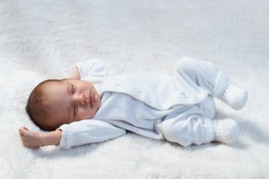 Yeni doğan bebek beyaz kürk güneş ışığı üzerinde uyku