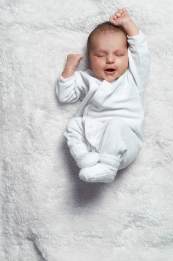 infant yawning stretches on  white fur clipart