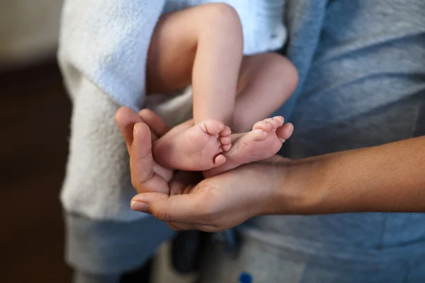 Mom keeps  miniature newborn leg in hand — Stock Photo, Image