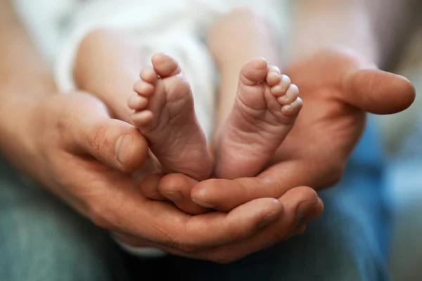 Papa hält kleinen Babyfuß in den Händen — Stockfoto