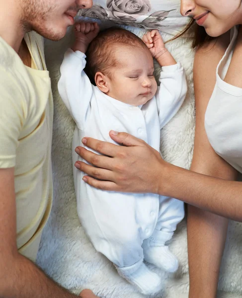 Neugeborenes liegt zwischen liebevollen Eltern — Stockfoto