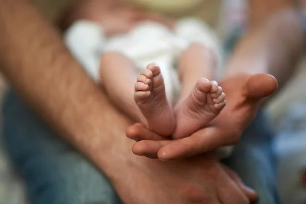 Baba onun elleri küçük bebek ayak tutar — Stok fotoğraf