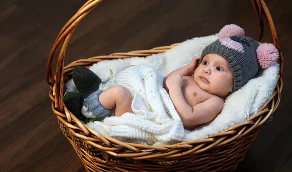 Newborn baby in  cap  basket on  floor — Stock Photo, Image