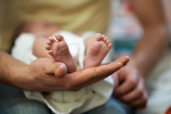 Papa heeft in zijn handen kleine baby voet — Stockfoto