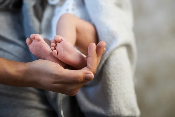 Mama hält Miniatur-Neugeborenenbein in der Hand — Stockfoto