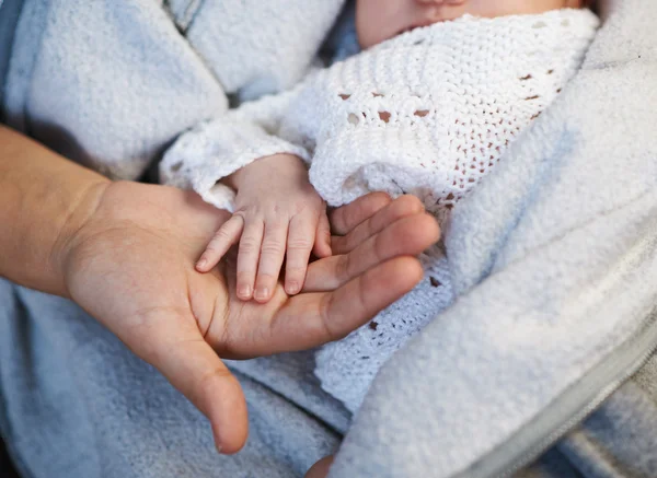 Mãe mantém a mão em miniatura bebê recém-nascido nas mãos — Fotografia de Stock