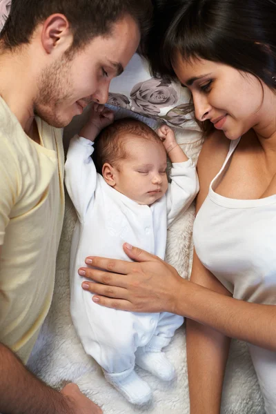 Novorozenec leží mezi milující otec a matka — Stock fotografie