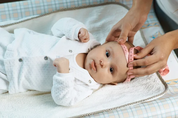 Therapist measures  size head of  beautiful baby — Stock Photo, Image