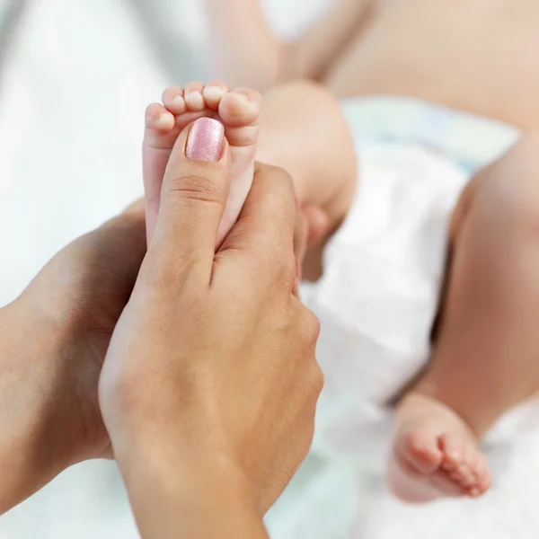 Maman vérifie réflexe enfant à pied — Photo