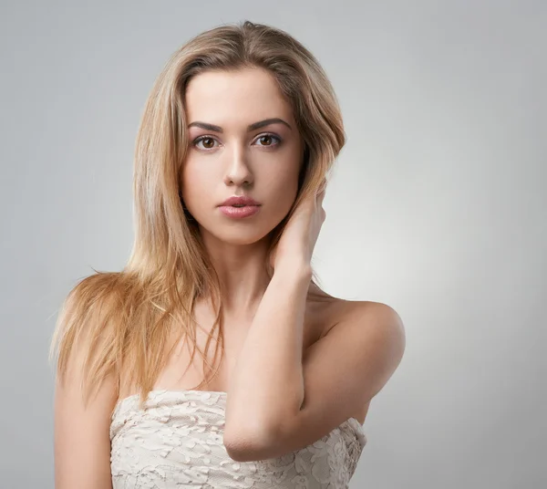 Portret van mooie blonde op een grijze achtergrond — Stockfoto