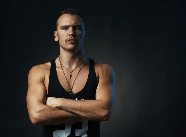 Man on black background with his arms crossed — Stock Photo, Image