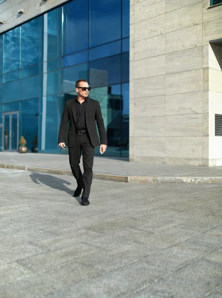 Бизнесмен прогуливается по улице возле офиса — стоковое фото