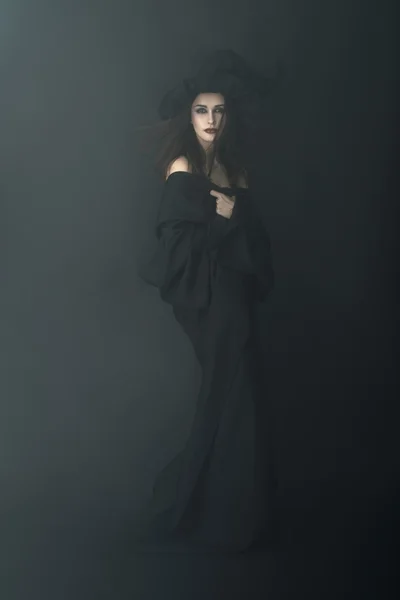 Slender witch in a dark fog — Stock Photo, Image