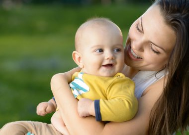 Mutlu anne bebeğini kollarında ile oynarken