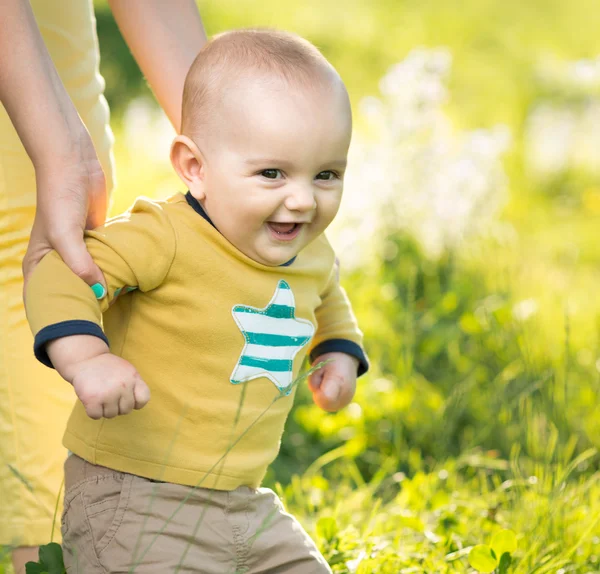 Pojken går på gräset av förälder — Stockfoto