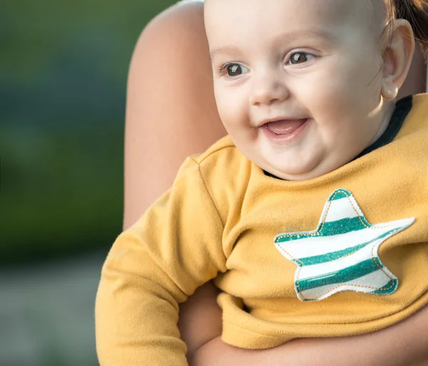 Glücklicher Junge in den Armen meiner Mutter, die wegschaut — Stockfoto