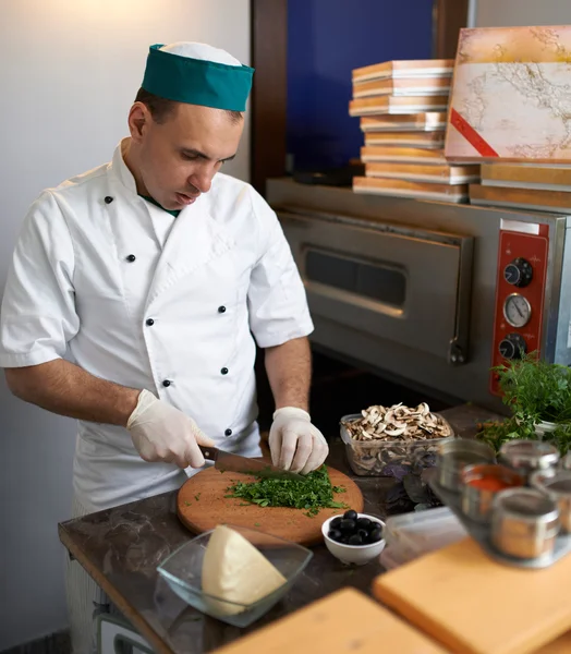 Chef in cucina tagliato prezzemolo pizza — Foto Stock