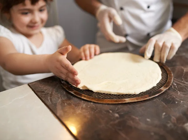 Flicka korrigerar hand kanten av pannkaka pizza — Stockfoto