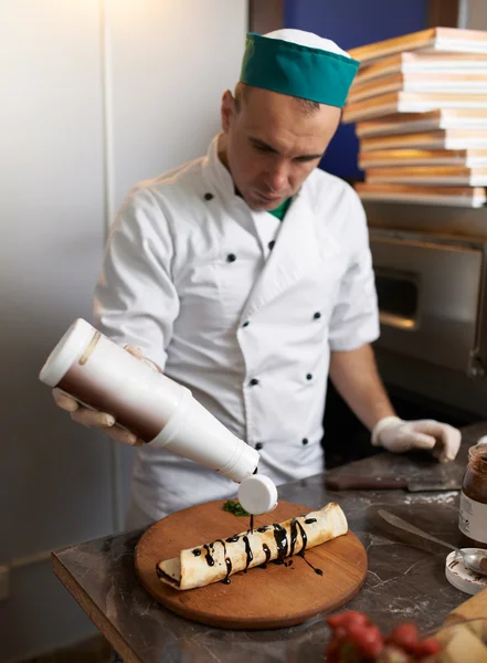 Chef-kok giet zoete roll met chocolade — Stockfoto