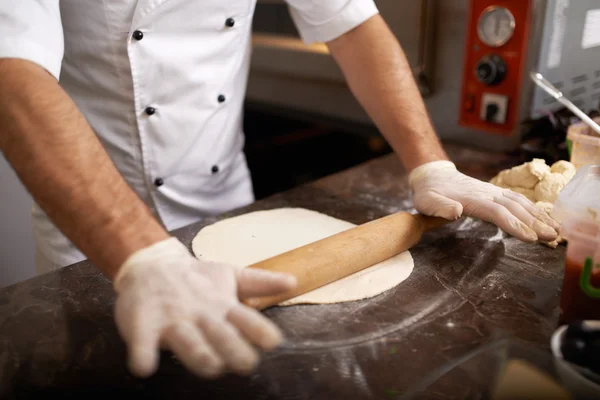 Koch rollt Pizzateig — Stockfoto