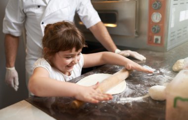  girl learns to roll out the dough