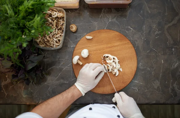 Chops mushrooms on board — Stockfoto