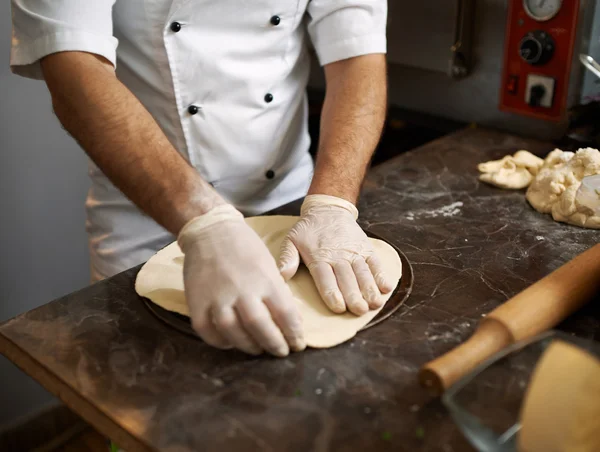 Chef stretches  pizza dough — Zdjęcie stockowe