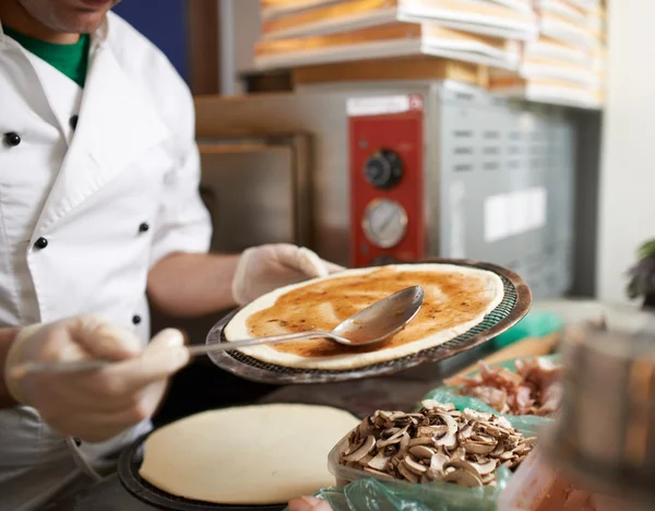 Cucchiaio di salsa spalma sulla pizza — Foto Stock