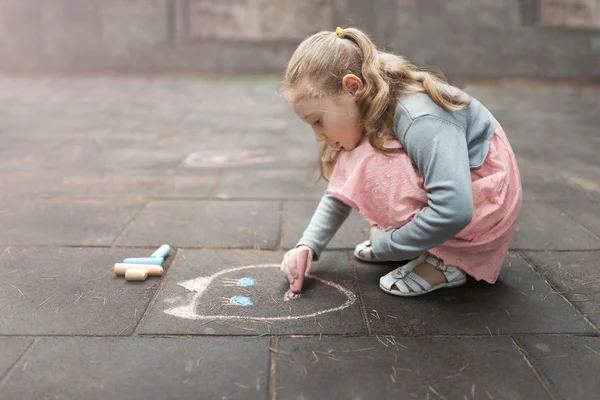Little girl draws chalk on asphalt — Stock Photo, Image