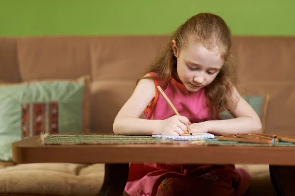 Serious girl painting  on paper — Φωτογραφία Αρχείου