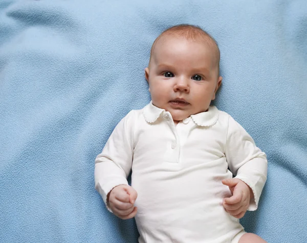 Porträt eines kleinen Kindes auf blauer Decke — Stockfoto