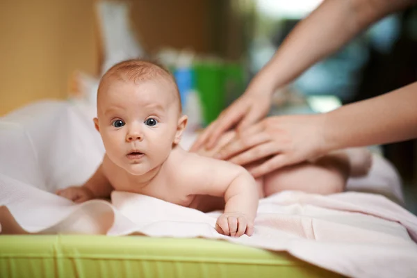 Mom makes  baby massage a little surprised — Zdjęcie stockowe