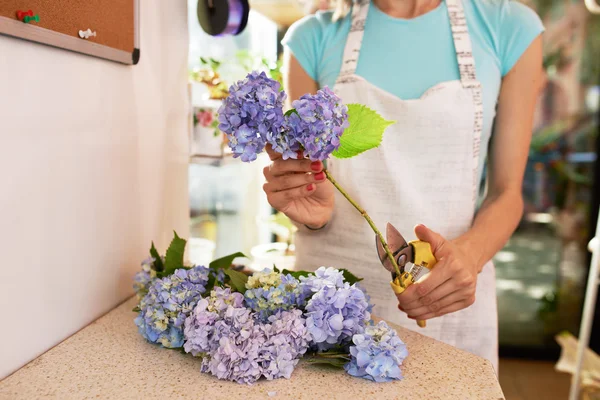 Florist cuts  stems of flowers for a bouquet — Stock Photo, Image