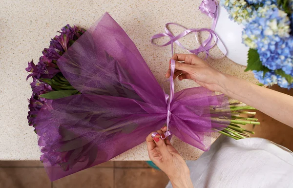 Florist tying the ribbon on  bouquet — Zdjęcie stockowe